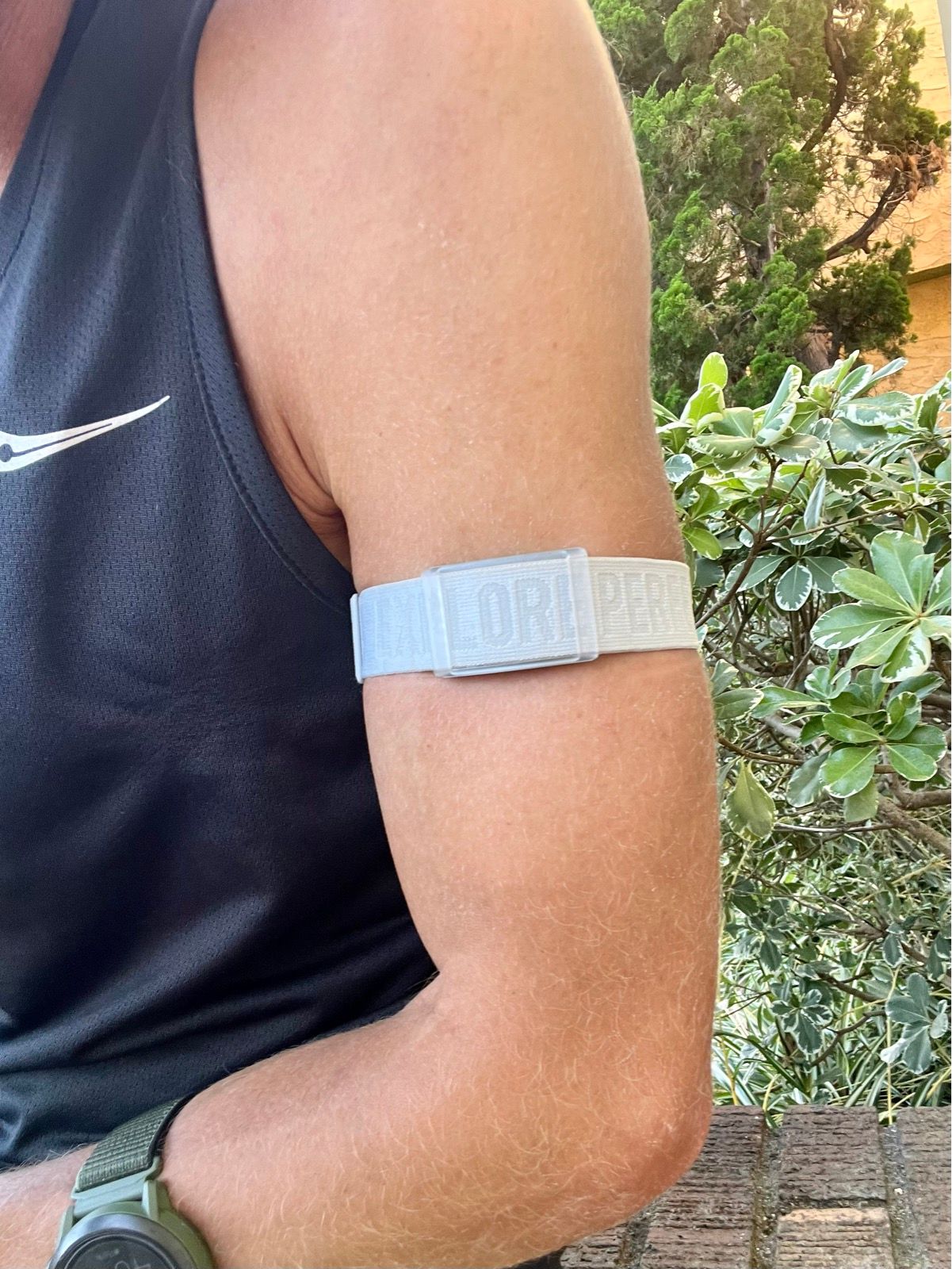 Control de pulsos. colocar chica en ropa deportiva gris fattaching el  pulsómetro en su brazo